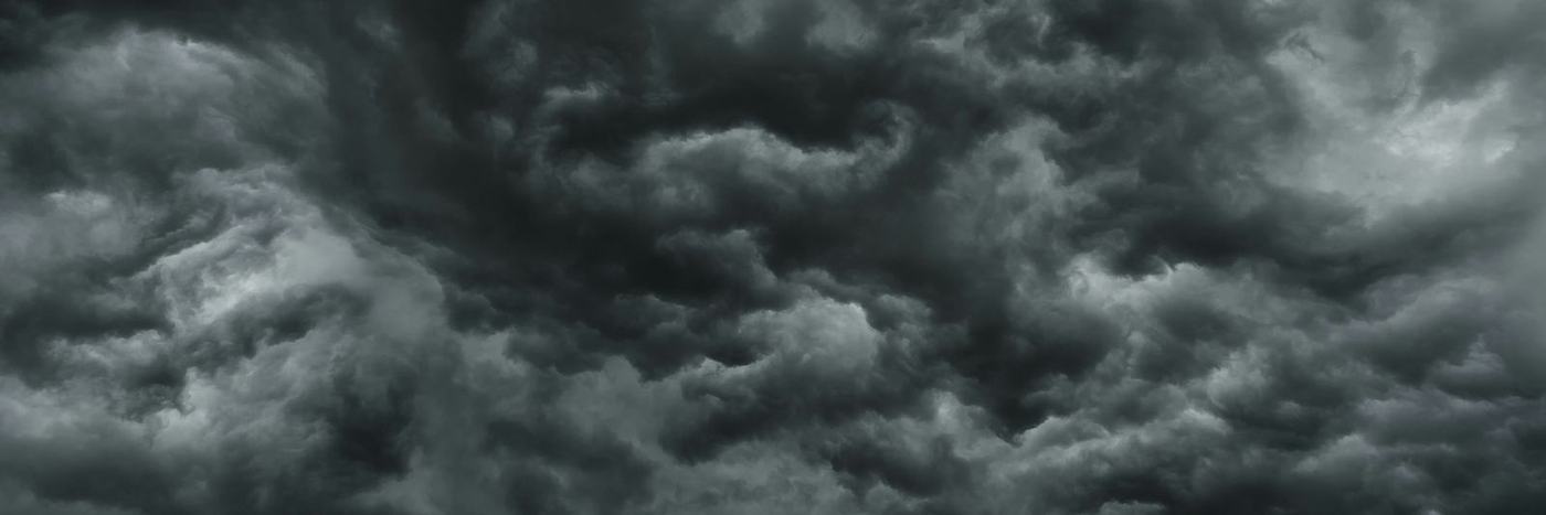 Dense dark grey storm clouds filling the sky with swirling patterns