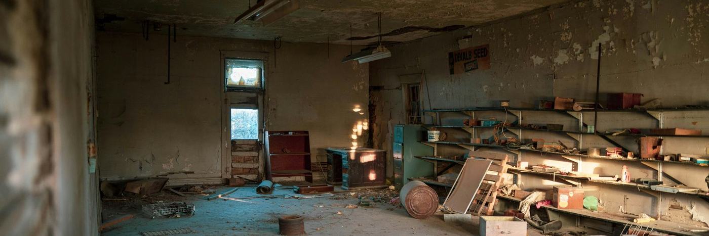 Dilapidated abandoned room with debris and sunlight from a window
